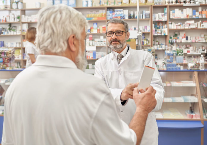 Pharmacien donnant des conseils à un retraité