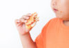 Jeune garçon obèse mangeant un handburger