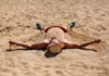 Homme couché sur le dos sur une plage en plein soleil