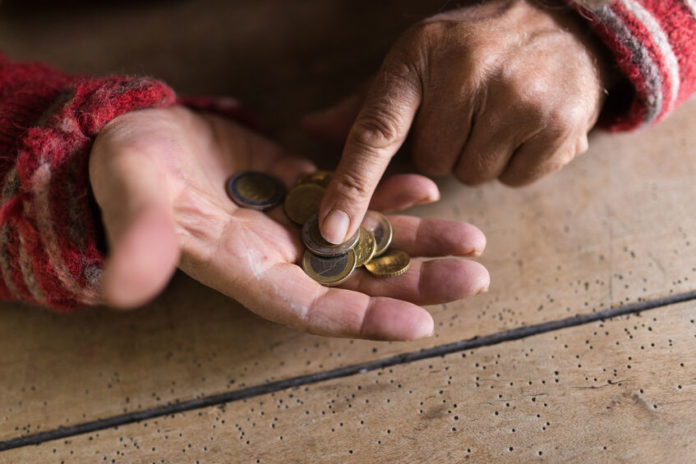 Mains d'une personne entrain de compter des pièces de monnaie