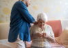 Femme aidant une personne âgée à s'habiller