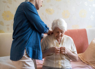 Femme aidant une personne âgée à s'habiller