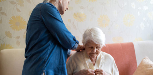 Femme aidant une personne âgée à s'habiller © 123 RF