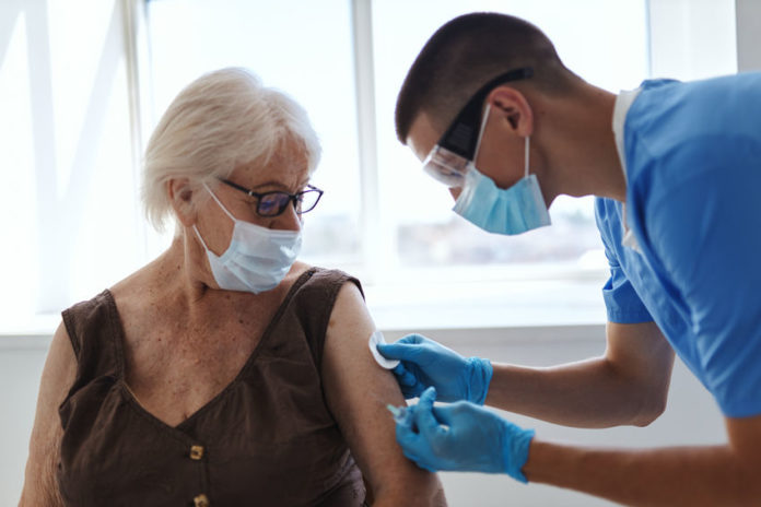 Docteur faisant un vaccin à une femme âgée, 123RF©